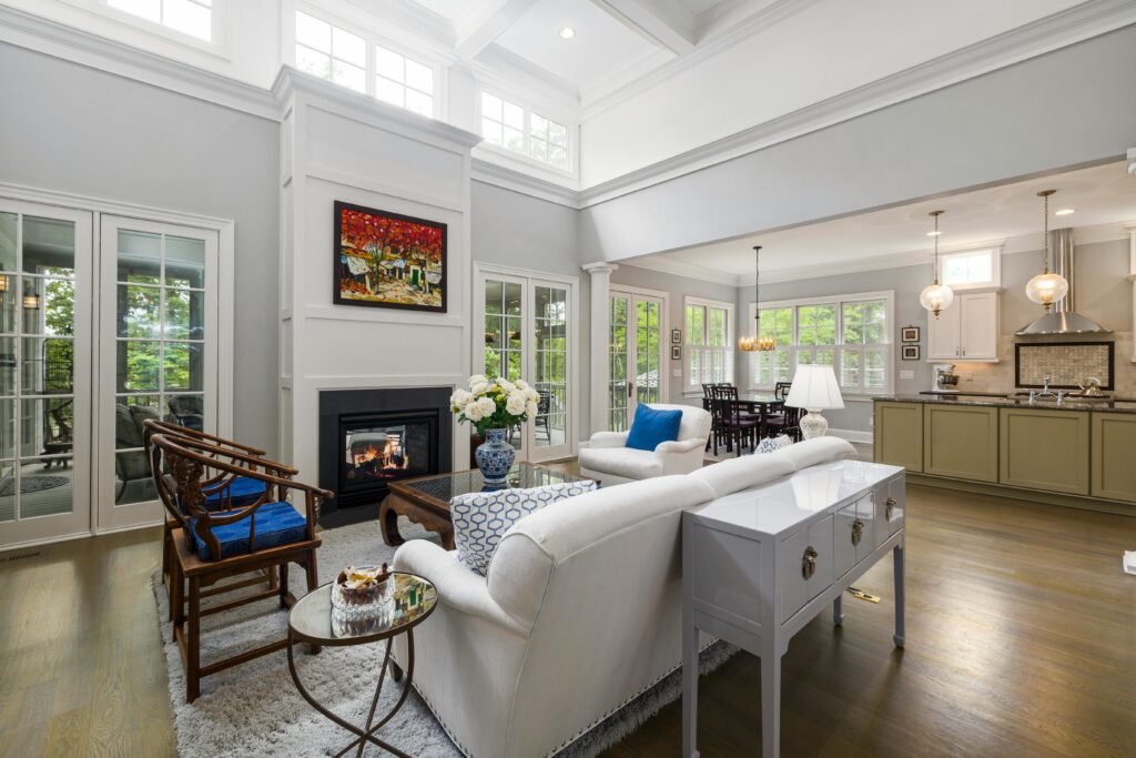 Spacious contemporary living room and kitchen with high ceilings and modern furniture.
